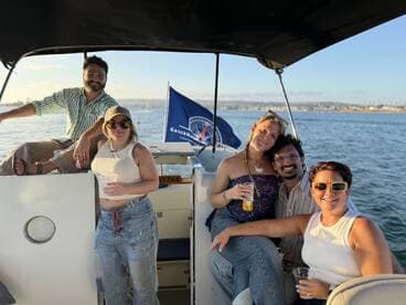 A cheerful group enjoys drinks on a boat, capturing the essence of a sunset cruise — perfect for celebrations and memorable outings on the water.