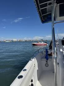 A scenic view from aboard a boat, showcasing another vessel on the water and a vibrant skyline in the background — perfect for enjoying a day out on the water.