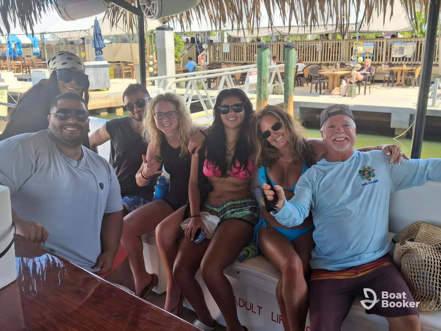A lively group of friends enjoys their time on a boat, capturing fun moments together — perfect for celebrating special occasions on the water.