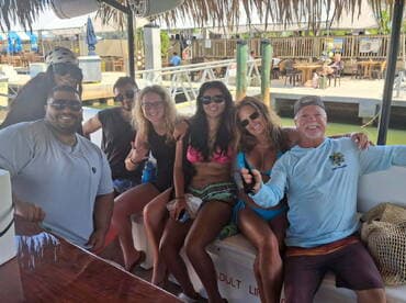 A lively group of friends enjoys their time on a boat, capturing fun moments together — perfect for celebrating special occasions on the water.