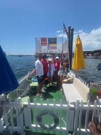 A lively group gathers on a boat deck, enjoying a sunny day on the water — perfect for celebrations and memorable outings.