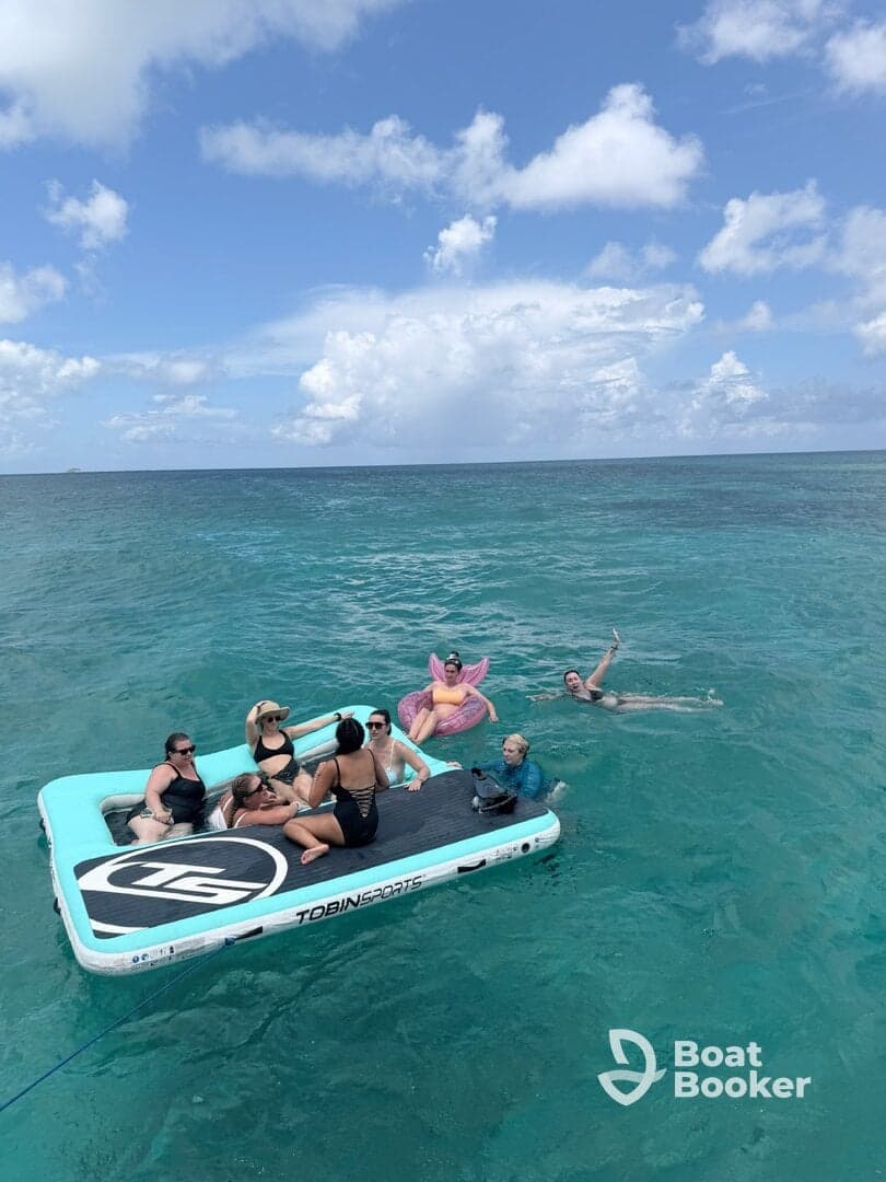 A lively group enjoys a day on a floating mat in the ocean, showcasing fun and relaxation under the sun.