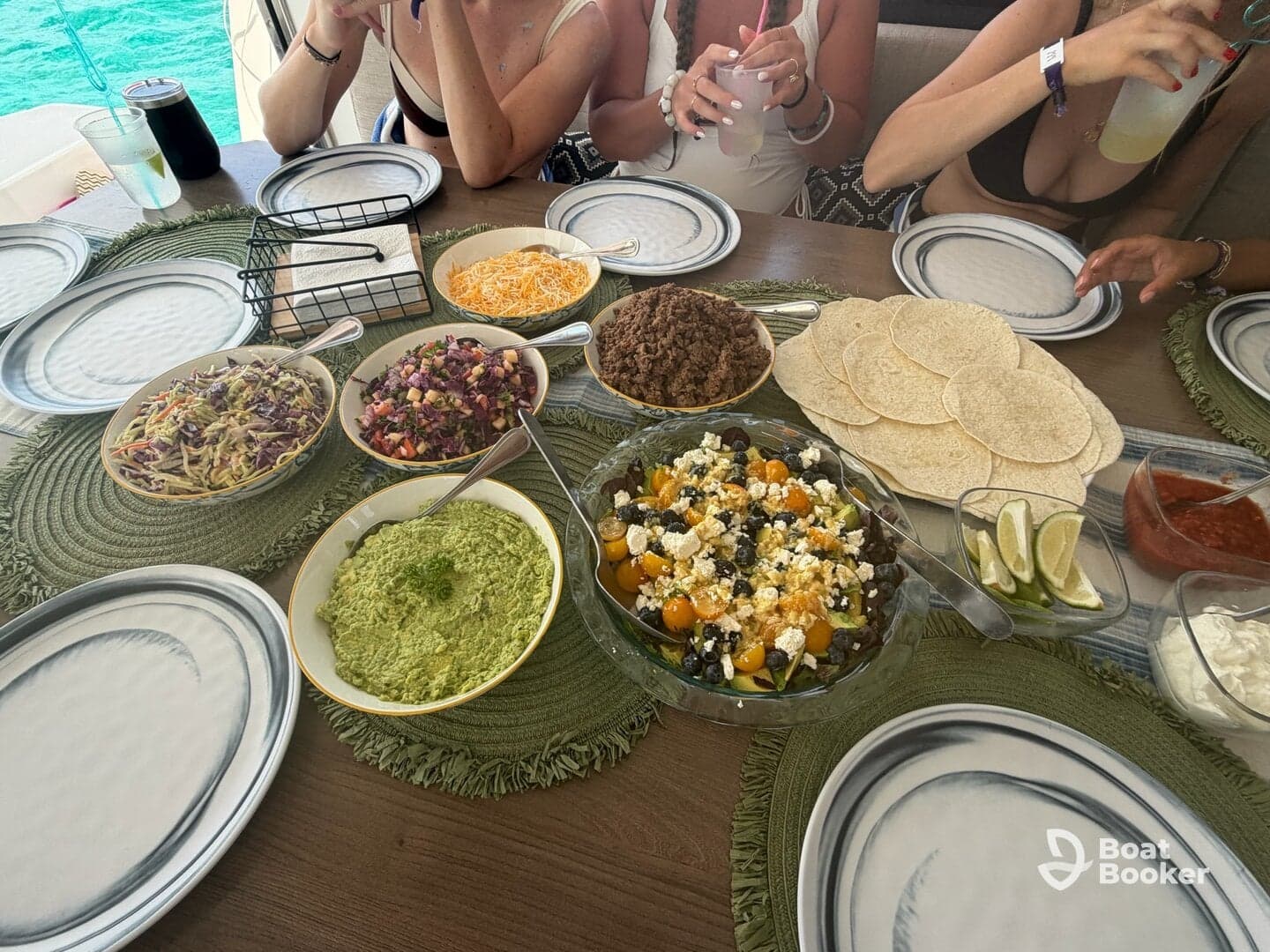 A vibrant spread of delicious taco ingredients and sides, perfect for a fun dining experience on the water. Guests enjoy a variety of fresh dishes while relaxing aboard.
