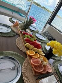 A beautifully arranged platter of fresh fruits on a boat dining table, perfect for enjoying snacks while cruising the waters.