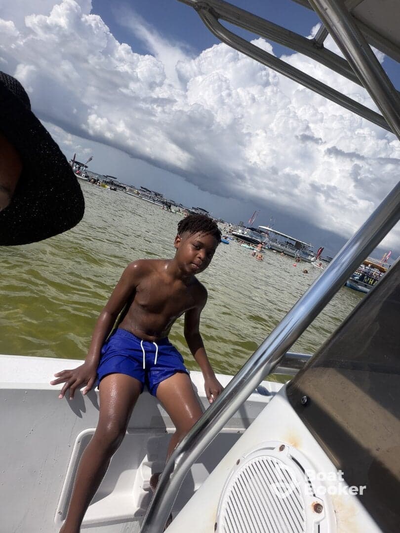 A young boy enjoys a sunny day on a boat, capturing the essence of summer fun on the water.