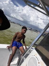 A young boy enjoys a sunny day on a boat, capturing the essence of summer fun on the water.