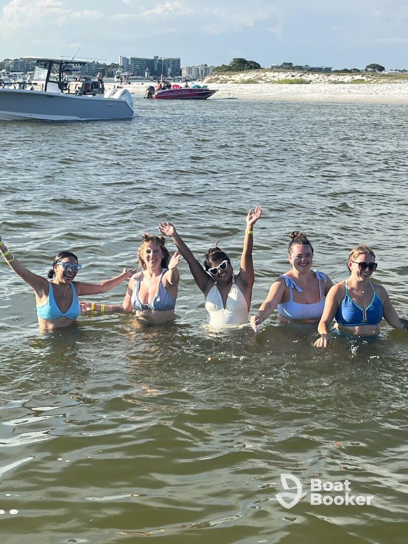 A lively group of friends enjoys a fun day swimming in the water, celebrating together under the sun — perfect for beach outings and summer adventures.