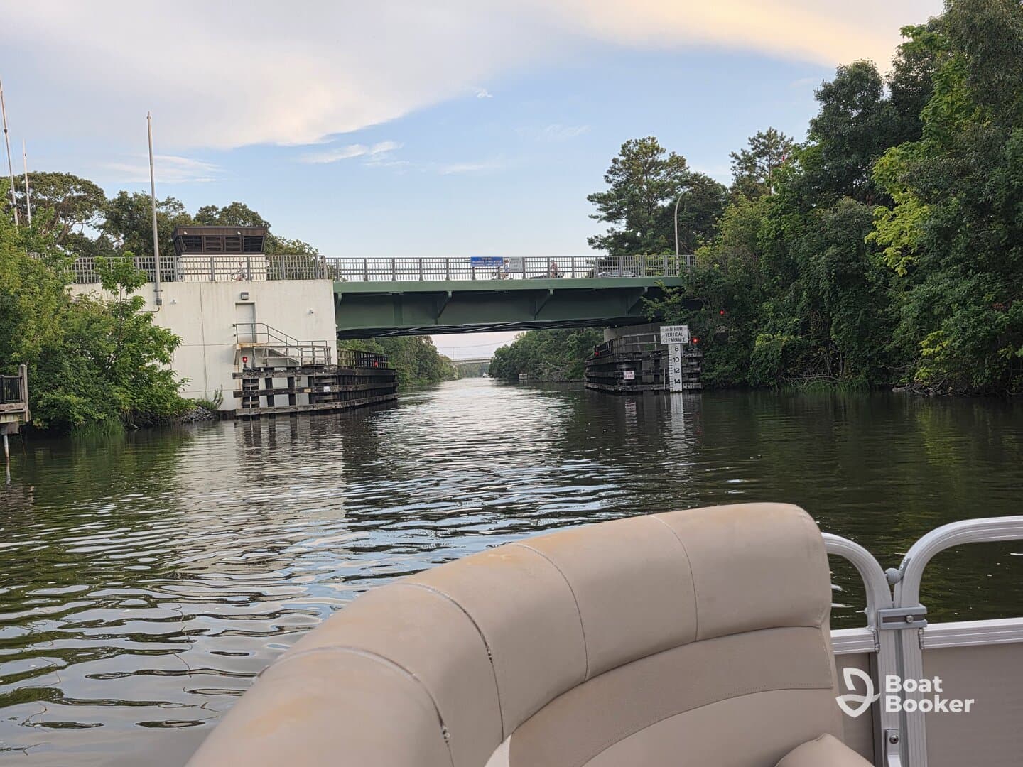 A scenic view of a waterway with a bridge overhead, showcasing the tranquility of boating through lush surroundings.