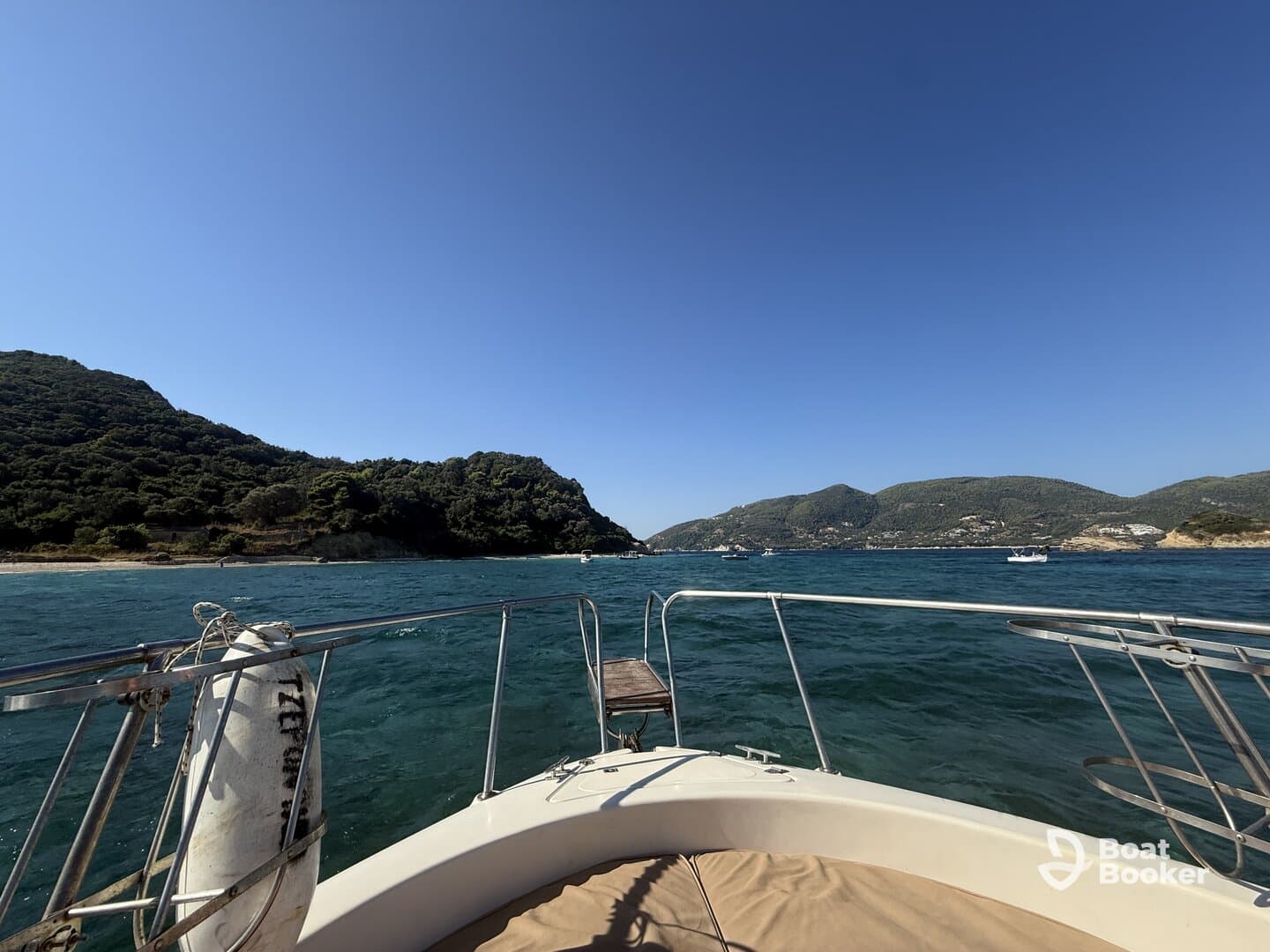 A scenic view from the bow of a boat, showcasing the lush green hills and clear waters, perfect for exploring coastal landscapes.
