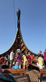 A lively group of family members engages in activities aboard a beautifully decorated boat, showcasing a fun and interactive experience on the water.