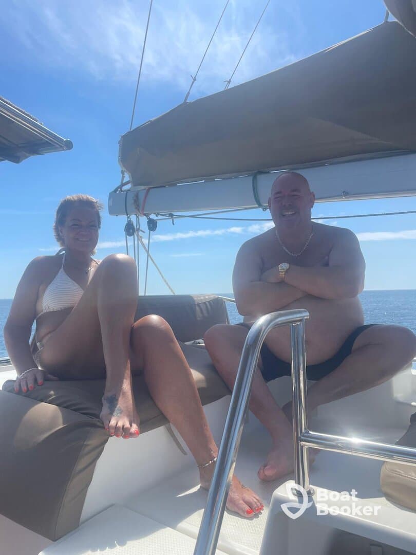 A couple enjoys a sunny day on a boat, relaxing and soaking up the sun — perfect for a romantic getaway or a day of leisure on the water.