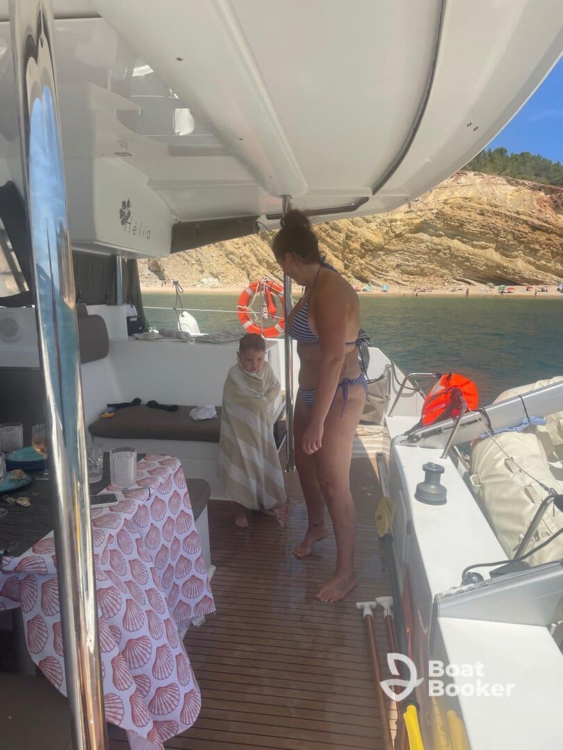 A cozy moment inside the boat as a woman tends to a child wrapped in a towel, showcasing the comfortable interior space perfect for family outings.