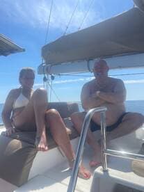 A couple enjoys a sunny day on a boat, relaxing and soaking up the sun — perfect for a romantic getaway or a day of leisure on the water.