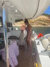 A cozy moment inside the boat as a woman tends to a child wrapped in a towel, showcasing the comfortable interior space perfect for family outings.