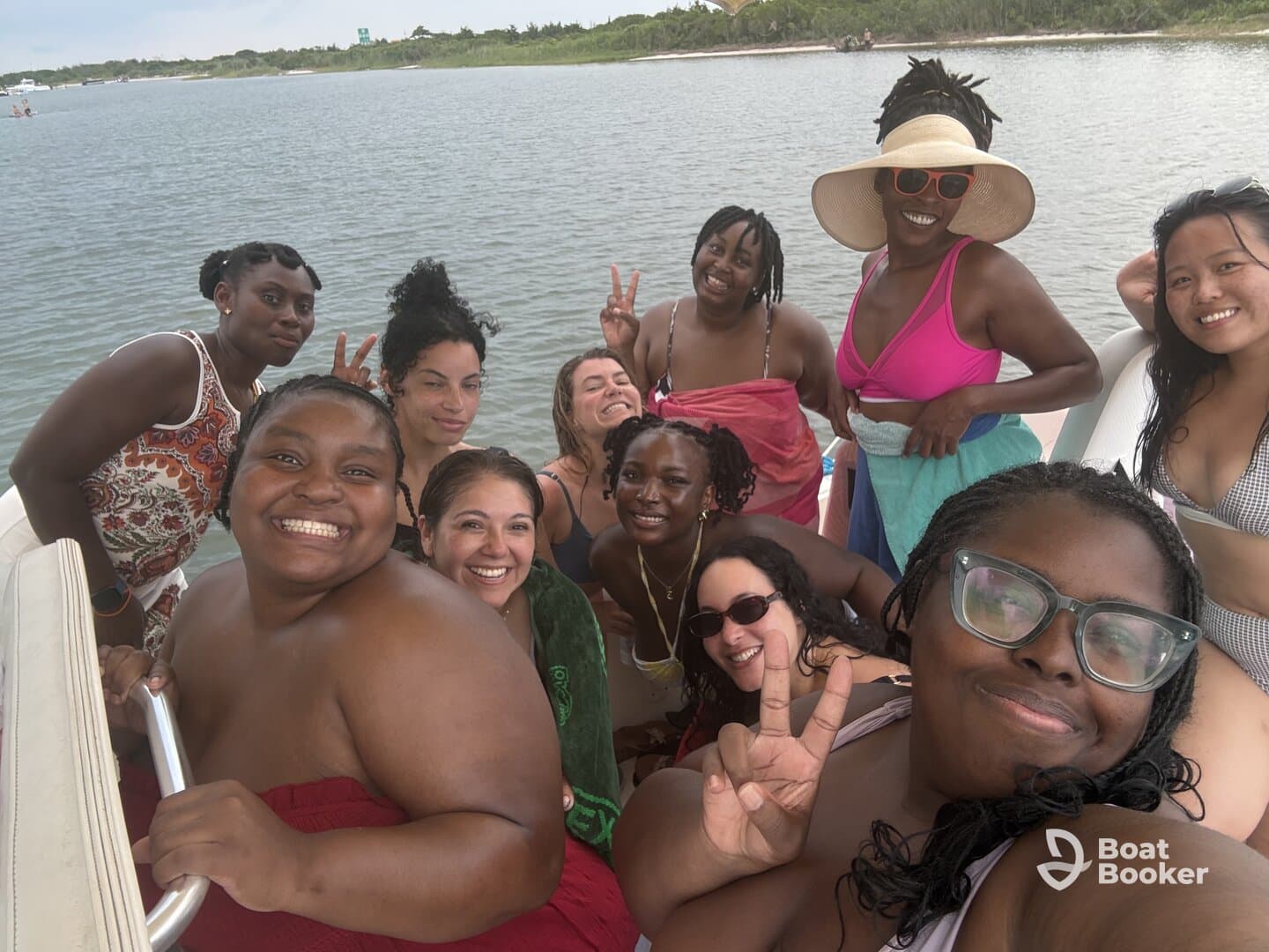 A joyful group of friends poses for a fun selfie on a boat, capturing the essence of a memorable day on the water with laughter and camaraderie.