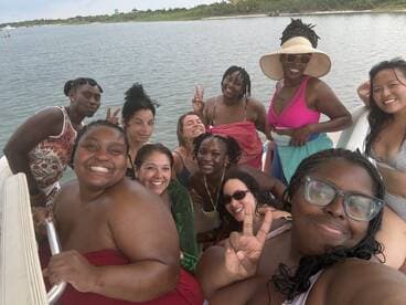 A joyful group of friends poses for a fun selfie on a boat, capturing the essence of a memorable day on the water with laughter and camaraderie.
