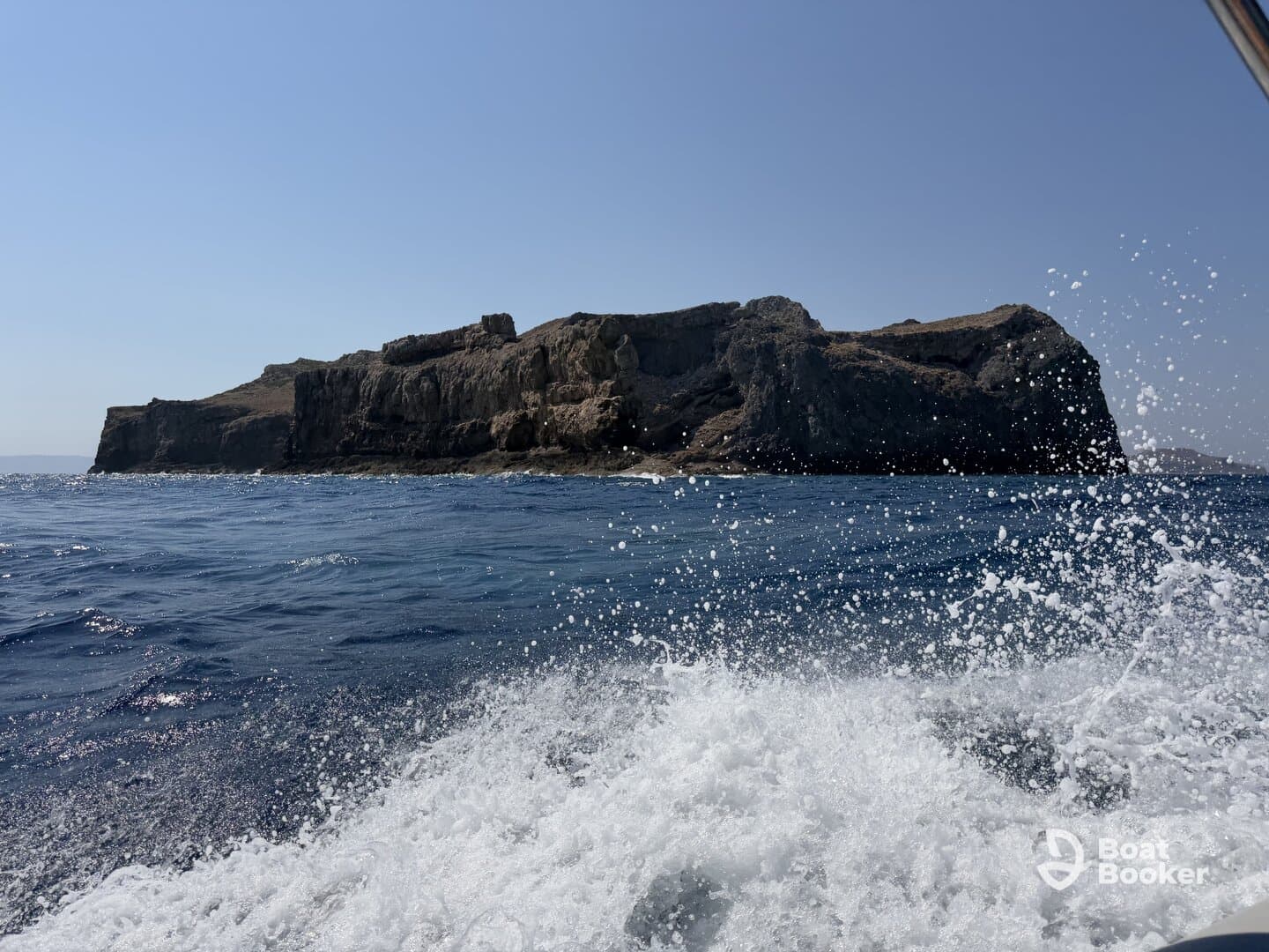 A stunning view of a rugged coastline from the water, showcasing the natural beauty of the island — perfect for adventure seekers and nature lovers.