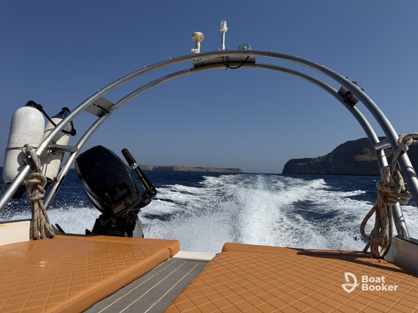 A view from the front of a boat cruising through open waters, showcasing the vessel's structure and the scenic coastline in the background.