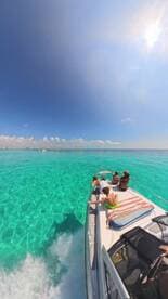A joyful group enjoys a sunny day on a boat, surrounded by stunning turquoise waters — perfect for family adventures and fun on the water.