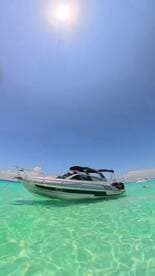 A sleek speedboat anchored in crystal-clear waters, perfect for enjoying sunny days on the water.