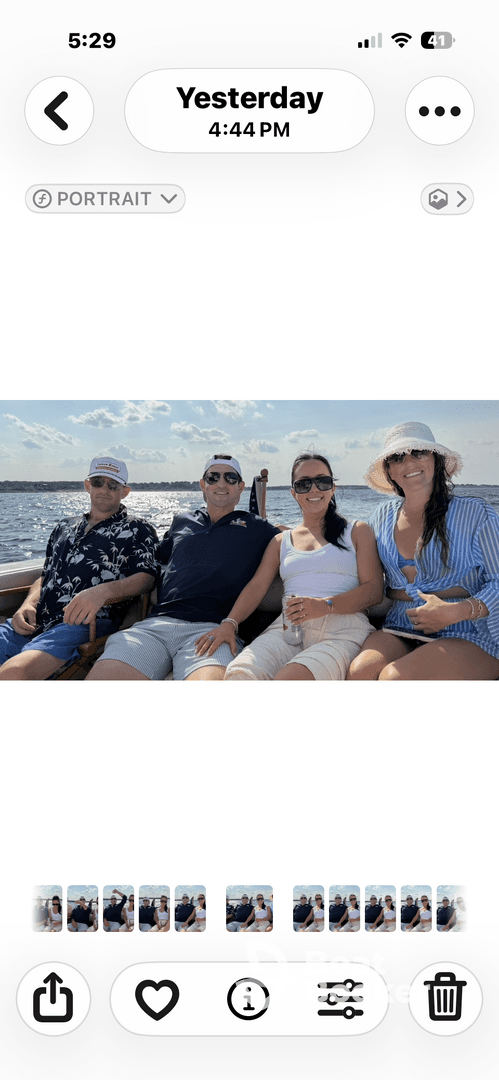 A cheerful group of friends enjoying a day on the water, capturing memories aboard a boat under a sunny sky.