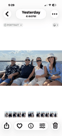 A cheerful group of friends enjoying a day on the water, capturing memories aboard a boat under a sunny sky.