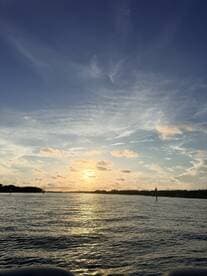 A stunning sunset over tranquil waters, capturing the beauty of nature and the serene coastline — perfect for romantic evenings or peaceful reflections.