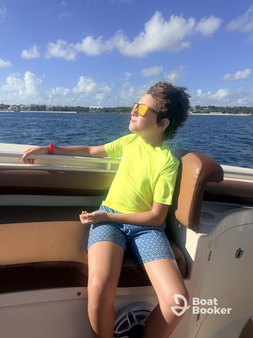 A young boy enjoys a sunny day on a boat, soaking in the views and relaxing in style — perfect for family outings on the water.