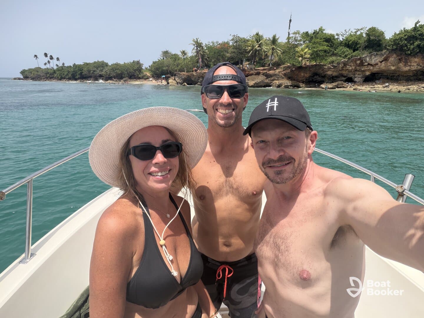 A cheerful group enjoys a sunny day on the boat, capturing a fun selfie against a beautiful tropical backdrop — perfect for memorable adventures on the water.