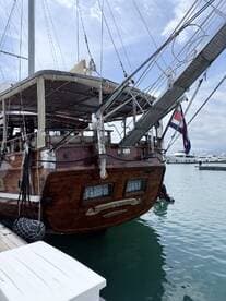 A beautifully crafted wooden yacht docked at the marina, showcasing its elegant design and craftsmanship.