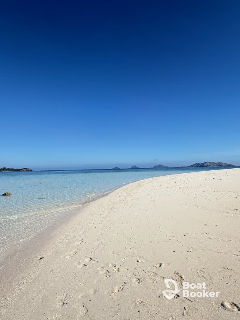 A stunning view of a pristine beach with soft white sand and crystal-clear waters, perfect for a relaxing getaway or beach day.