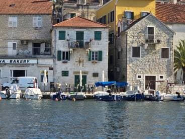 A picturesque view of a harbor featuring various boats docked alongside charming waterfront buildings, perfect for capturing the essence of coastal life.