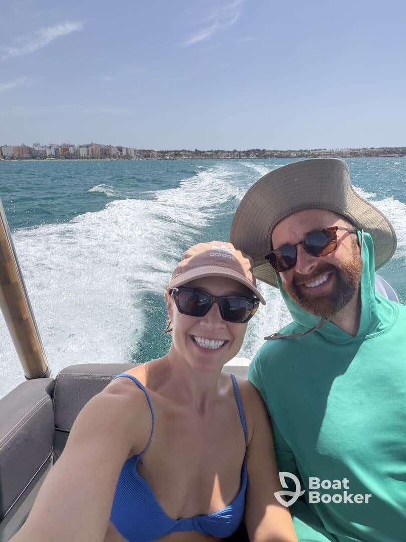 A cheerful couple enjoys a sunny day on the water, capturing the joy of boating with smiles and scenic views in the background.