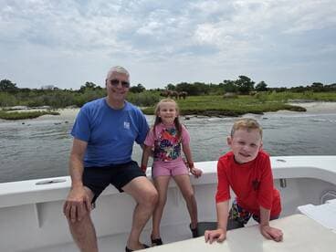 A joyful family moment on a boat, with children smiling and enjoying the scenic view of nature in the background — perfect for family outings and adventures on the water.