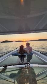 A couple enjoys a romantic sunset view from the deck of a boat, creating the perfect atmosphere for memorable moments on the water.