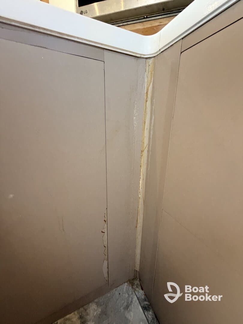 Close-up view of the interior corner of a boat cabin showing signs of wear and damage, highlighting the need for maintenance and care.
