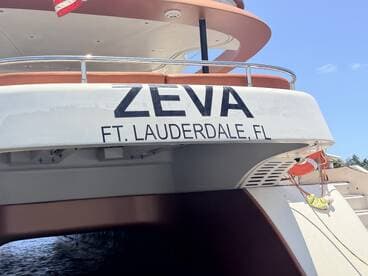 Close-up view of the 'ZEVA' boat docked in Fort Lauderdale, FL, showcasing its sleek design and name.