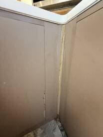Close-up view of the interior corner of a boat cabin showing signs of wear and damage, highlighting the need for maintenance and care.