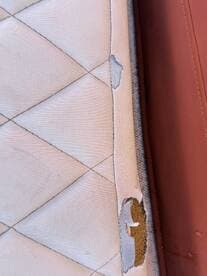 Close-up of a damaged boat cushion, highlighting wear and tear that may require repair or replacement for optimal comfort on board.