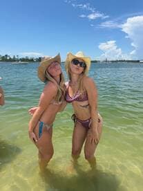 Two friends pose playfully in the water, showcasing a fun beach day with sun and smiles — perfect for summer adventures.