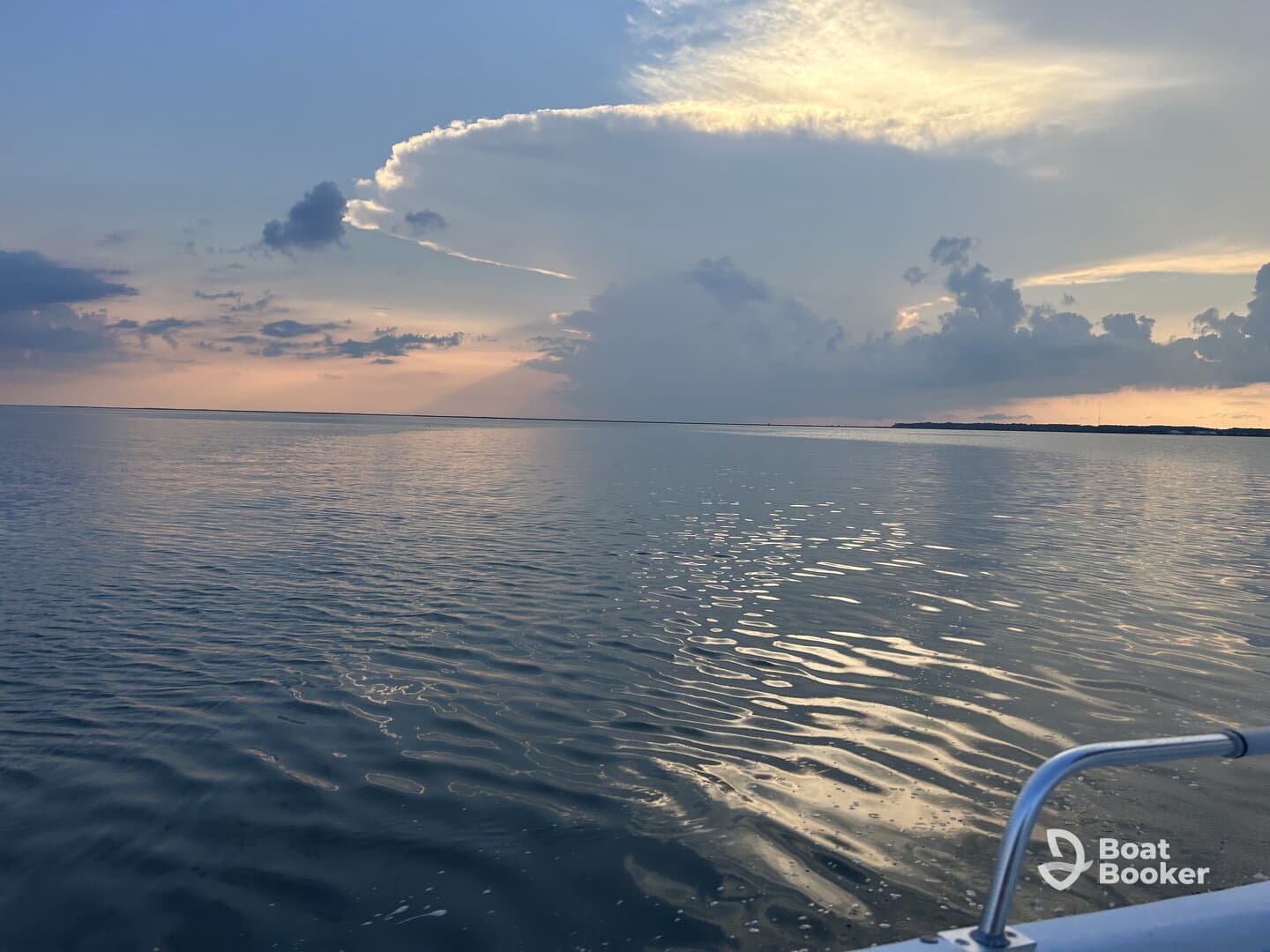 A serene sunset view over calm waters, showcasing the beauty of nature from a boat perspective — perfect for tranquil evening cruises.