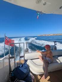 A child enjoys the ride on a boat, taking in the beautiful scenery as it speeds through the water — a perfect moment for family adventures on the sea.