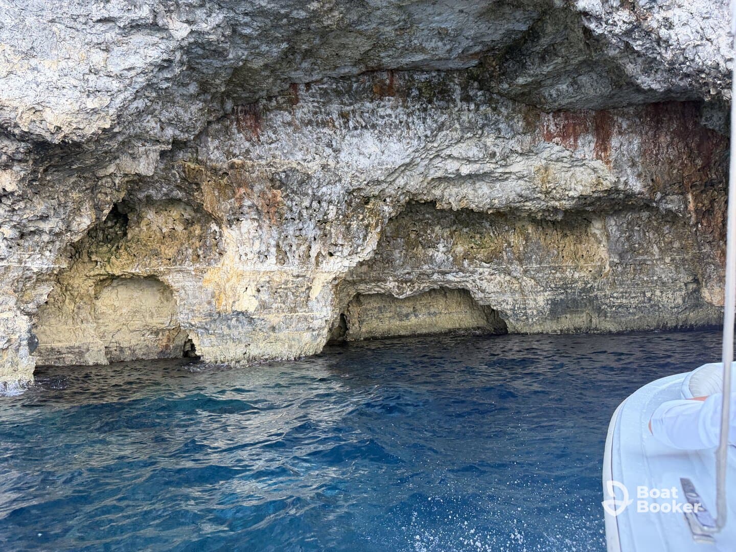 A stunning view of a rocky cave along the coastline, showcasing the natural beauty of the area — perfect for exploring by boat.