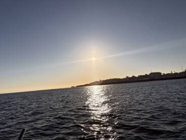 A serene sunset view over the water, showcasing the tranquil beauty of the horizon and the shimmering sea, ideal for peaceful evening boat rides.