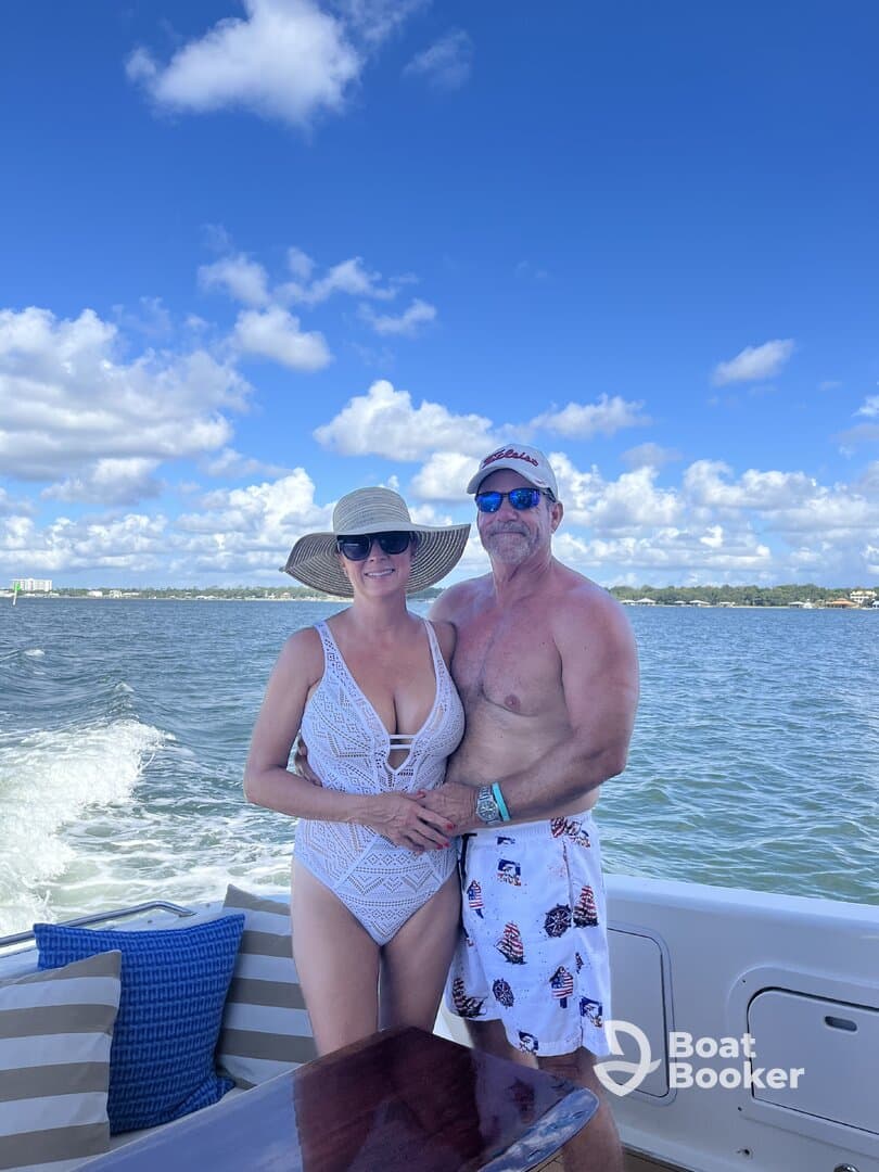 A couple enjoys a sunny day on the boat, capturing a romantic moment against a beautiful sky — perfect for memorable outings on the water.