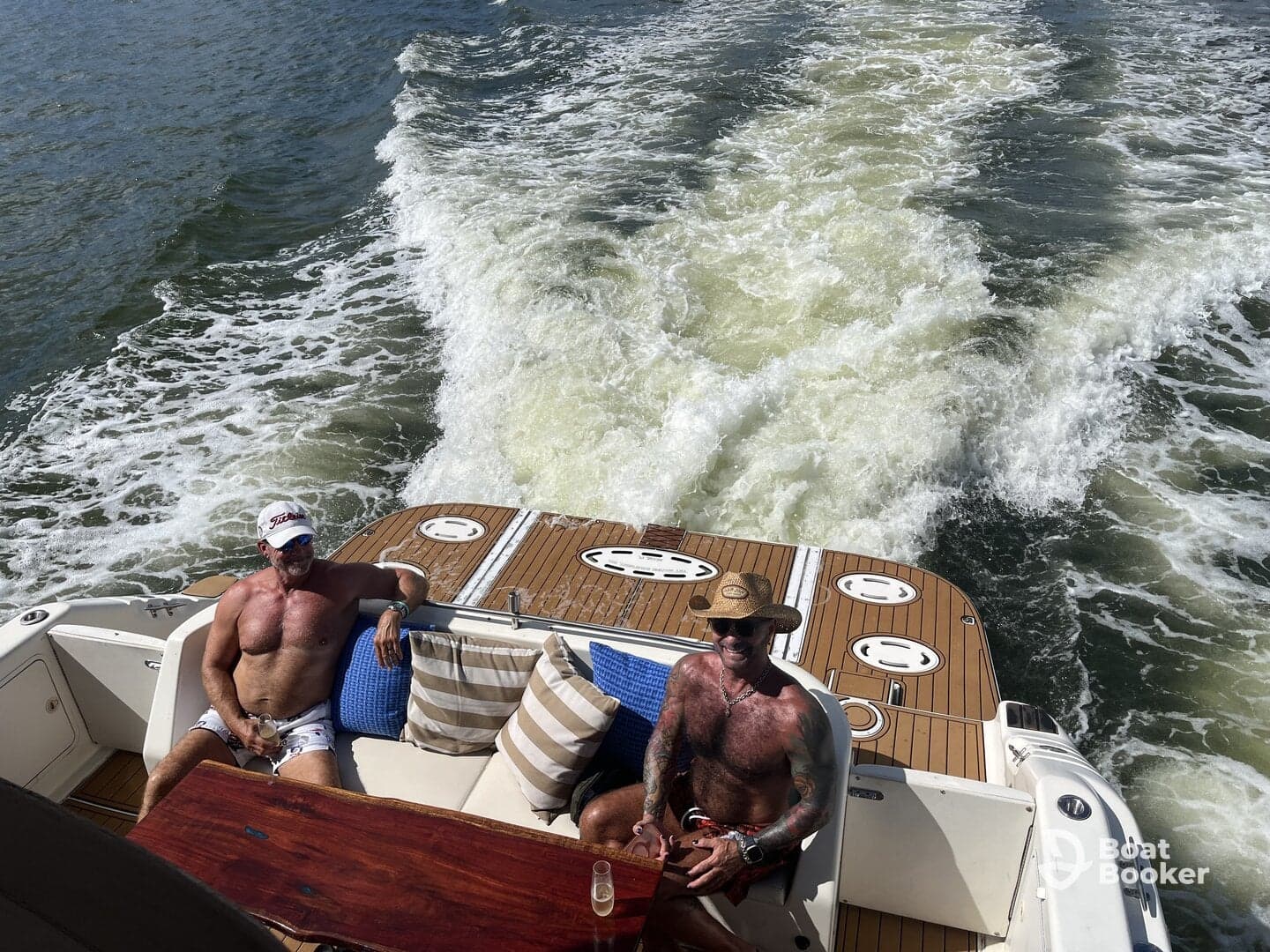 Two friends relax on the deck of a boat, enjoying the sun and the waves — a perfect day for boating and camaraderie.