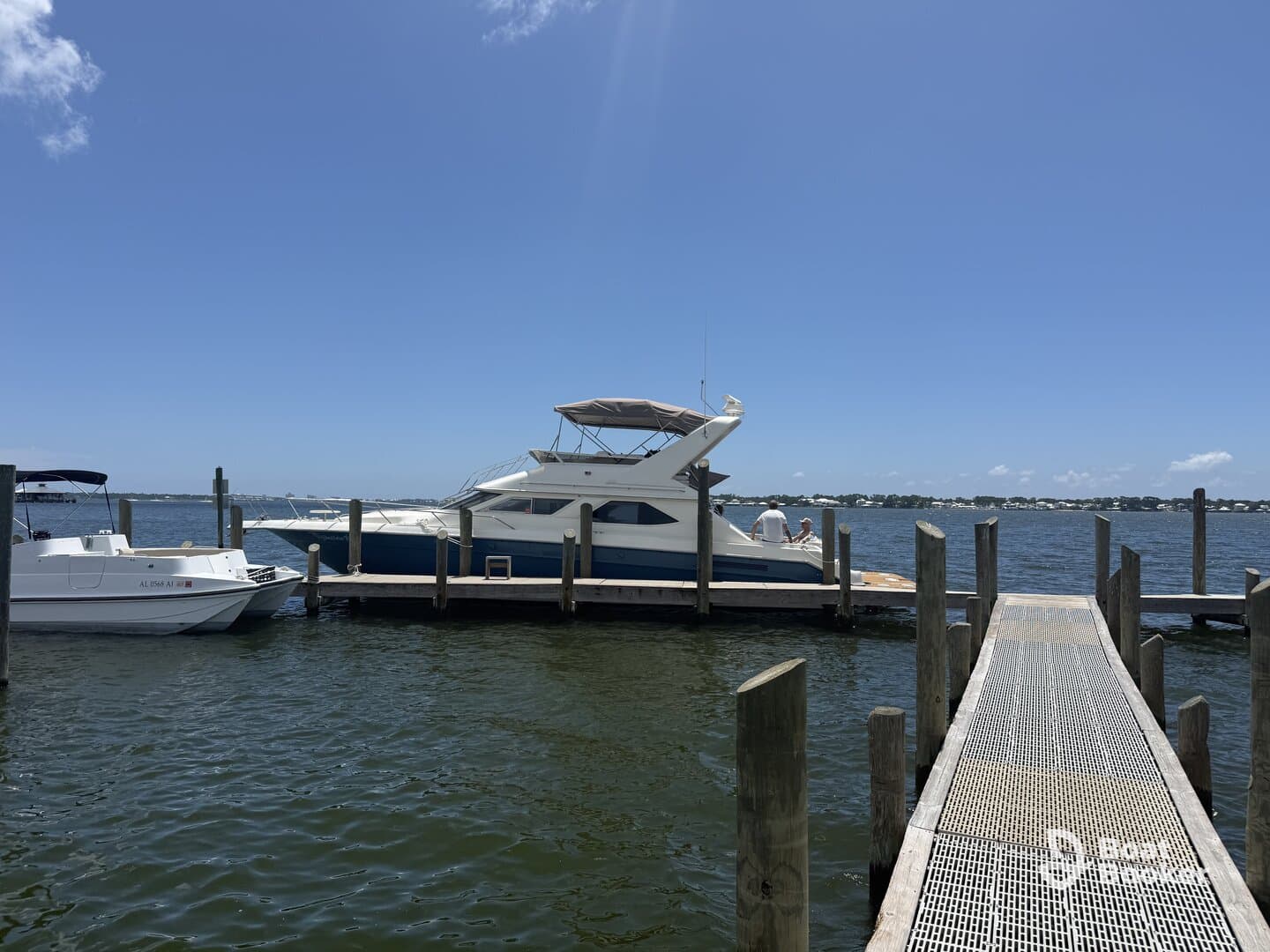 A beautiful yacht docked at the marina, showcasing its sleek design against a clear blue sky. Perfect for luxury boating experiences.