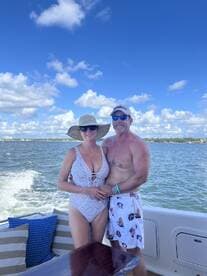 A couple enjoys a sunny day on the boat, capturing a romantic moment against a beautiful sky — perfect for memorable outings on the water.
