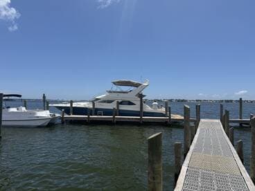 A beautiful yacht docked at the marina, showcasing its sleek design against a clear blue sky. Perfect for luxury boating experiences.