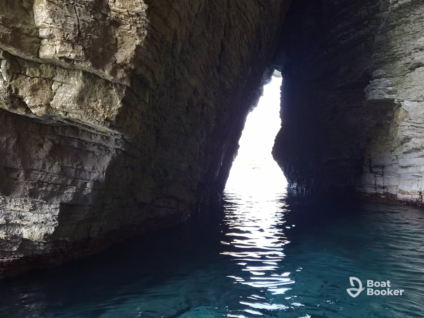A stunning view of a natural cave opening, revealing bright light and tranquil waters — a perfect representation of coastal exploration.